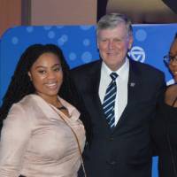 Two alumnae pose for a photo with T.Haas
